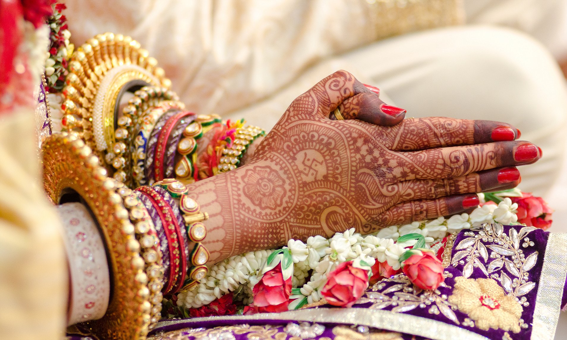 Traditional bridal jewelry and henna decoration on the hands of the bride during a religious ceremony at a Hindu wedding in Jaipur.