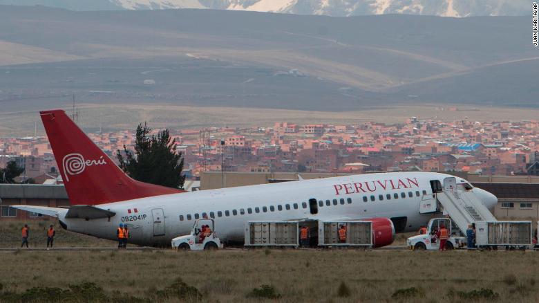 A Peruvian aircraft arriving from Cuzco blocks the runway after having problems landing as workers try to tow it away at the airport in El Alto, Bolivia, Thursday, Nov. 22, 2018. The aircraft blocked the tarmac for several hours, and its occupants were unharmed, according aviation authorities. (AP Photo/Juan Karita)