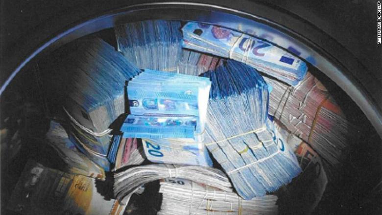In this image released by the Amsterdam Police on Thursday Nov. 22, 2018, confiscated money is seen. Police in Amsterdam say they have detained a 24-year man on suspicion of money laundering after discovering 350,000 euros (dollars US 400,000) in cash hidden in a washing machine. Police said in a statement Thursday that officers were checking a house in western Amsterdam on Monday for unregistered residents when they found the valuable laundry load. (Dutch Police via AP)
