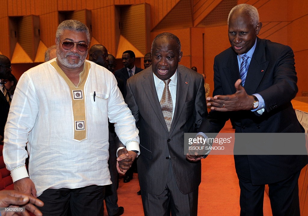 Mr. Rawlings (L), then President of Ivory Coast, Laurent Gbagbo, and ex-senegalese President and Secretary-General of La Francophonie Abdou Diouf (R) hold hands in the Felix Houphouet-Boigny Foundation during the 50th anniversary celebration ceremony of the Bar in the Ivory coast, June 25, 2009