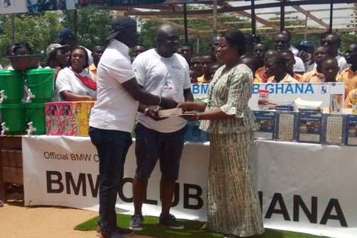 BMW Club Ghana President, Kojo Oppong and Dr. Asante Appiah, presenting the items to the Headmistress of Sagakope D/A Basic C