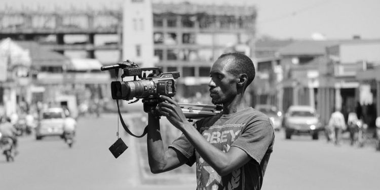 A journalist at work with his camera. Wikimedia Commons