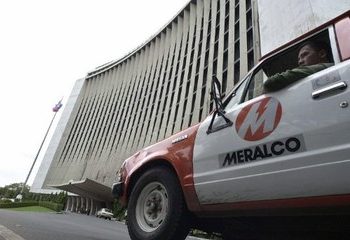 A service vehicle drives past the head office of the Manila Electric Co. (Meralco), 14 January 2003 in Manila, the flagship of the business group of the influential Lopez family in the Philippines. Meralco is marking its centennial this year but the Lopez group of companies, which include light, water and entertainment firms, is still trying to recover from the effects of the 1997-1998 Asian financial crisis. AFP PHOTO/Romeo GACAD