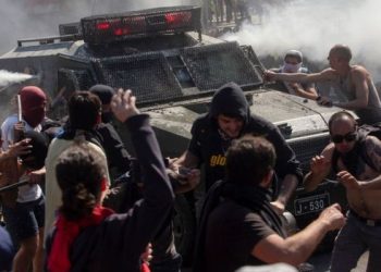 Demonstrators clash with a riot police vehicle in Santiago