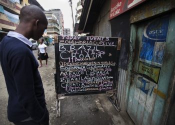 A Kenyan man checks out the Football World Cup fixtures. Matches are often screened in small viewing centres