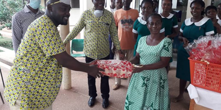 A staff of Olam Grains presents loaves of bread to hospital authorities at Korle Bu Teaching Hospital.