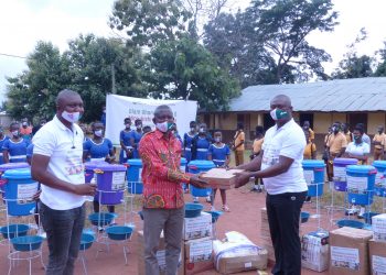 Mr. Yussif Amankwa (right), Branch Operations Manager, Olam Cashew, hands over the supplies to Mr. Opoku Donyina (middle) District Director of Education, Nkoranza North as Mr. Rowell Weroyi, Zonal Head, Cashew looks on.