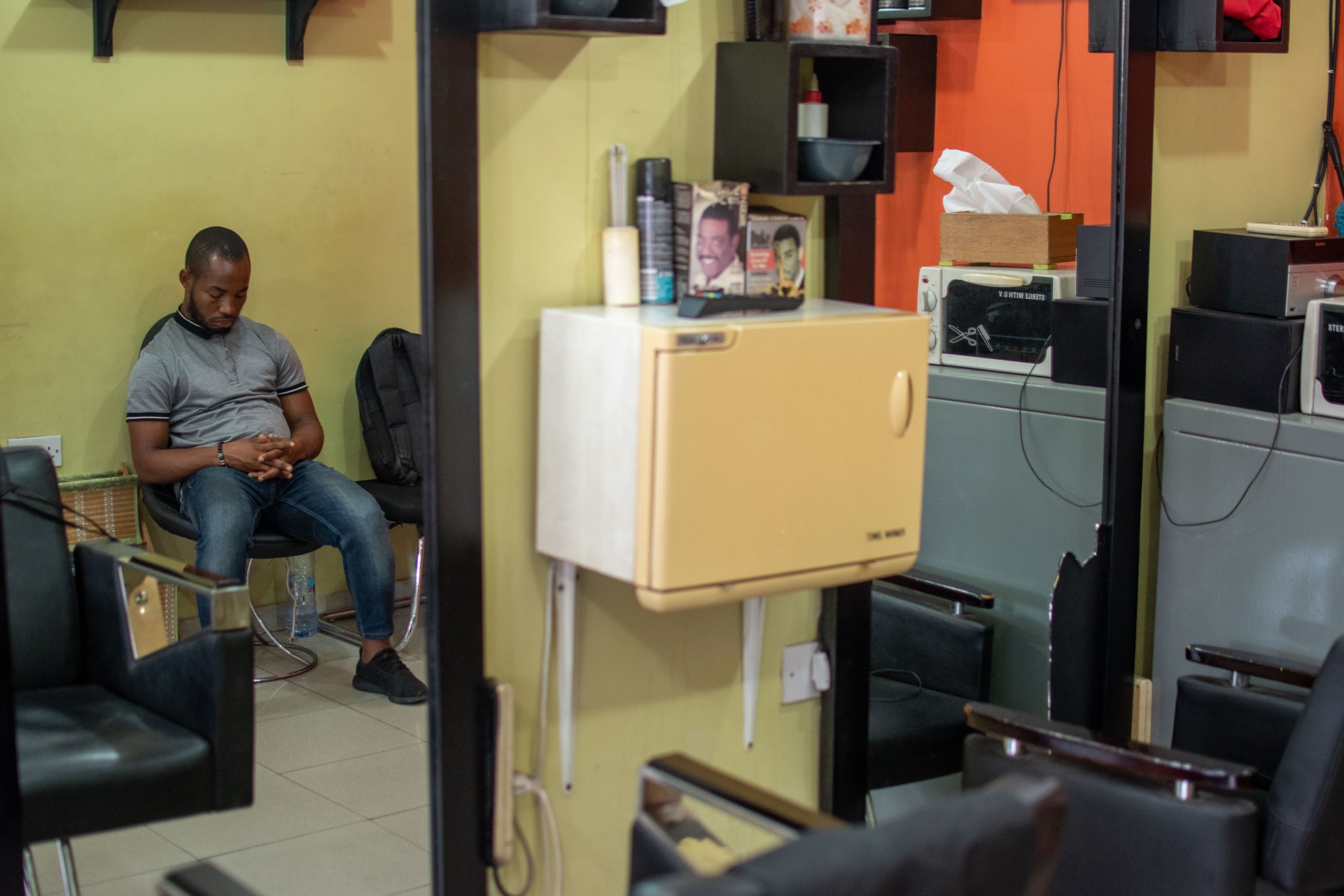 Slow business days are more regular for Tony Commey's barbering saloon