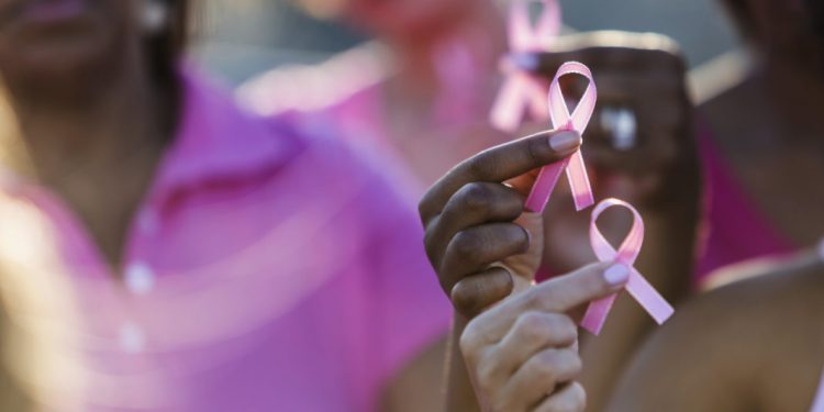 Cropped group of multi-ethnic teenage girls and young women holding breast cancer awareness ribbons in their hands, and wearing pink shirts.  Credit: Getty Images/iStockphoto