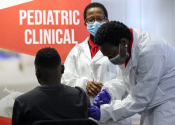 A health worker administers a vaccine during the launch of the South African leg of a global Phase III trial of Sinovac's COVID-19 vaccination of children and adolescents, in Pretoria, South Africa, September 10, 2021. REUTERS/Siphiwe Sibeko