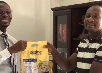 CEO of Western Deedew, Alfred Amof presents a sample of his rice to Citi CBS Host, Bernard Avle.