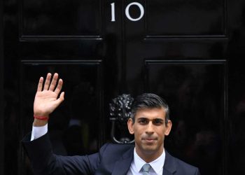TOPSHOT - Britain's newly appointed Prime Minister Rishi Sunak waves as he poses outside to door to 10 Downing Street in central London, on October 25, 2022, after delivering his first speech as prime minister. - Rishi Sunak was on Tuesday appointed as Britain's third prime minister this year, after outgoing leader Liz Truss submitted her resignation to King Charles III. (Photo by Daniel LEAL / AFP) (Photo by DANIEL LEAL/AFP via Getty Images)