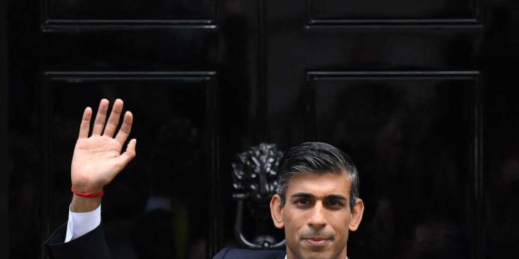 TOPSHOT - Britain's newly appointed Prime Minister Rishi Sunak waves as he poses outside to door to 10 Downing Street in central London, on October 25, 2022, after delivering his first speech as prime minister. - Rishi Sunak was on Tuesday appointed as Britain's third prime minister this year, after outgoing leader Liz Truss submitted her resignation to King Charles III. (Photo by Daniel LEAL / AFP) (Photo by DANIEL LEAL/AFP via Getty Images)