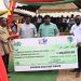 Dr. James Rajamani, CEO of Kingdom Exim Group supported by the Dr Emmanuel Rajamani (MD) presenting a dummy cheque to the Bono East Regional Minister (In smock) during the 38 Regional farmers day in Atebubu