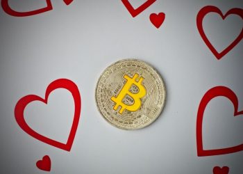 Digital currency physical metal bitcoin coin with love hearts scene.