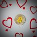 Digital currency physical metal bitcoin coin with love hearts scene.
