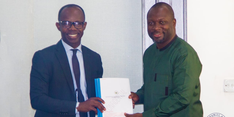 Dr. Antwi-Boasiako, Director General of the Cyber Security Authority presenting a copy of the guideline to Mr. John Awuah, President of the Ghana Association of Banks