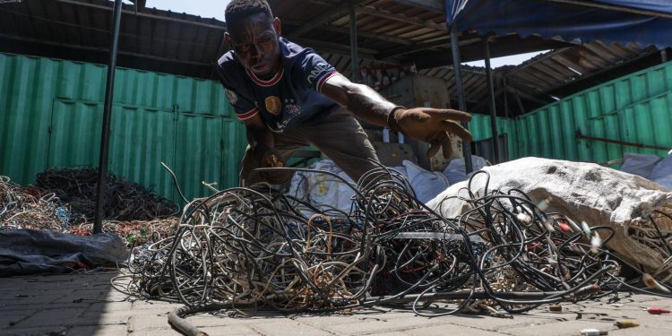 A worker in GreenAd’s facility throws the heads of the cables after he dismantles them. (Photo by Yannick Peterhans)