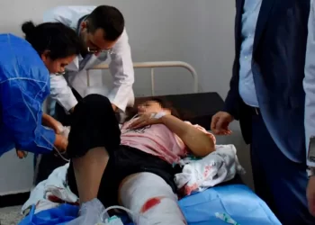 Doctors treat a Syrian woman injured from a drone attack that hit a packed military graduation ceremony in the central city of Homs, Syria, Oct 5, 2023. A portion of this image has been blurred by CNN to protect an individual's identity.