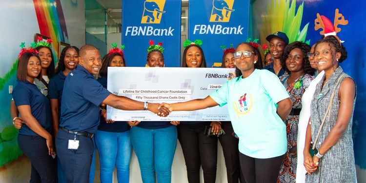 Allen Quaye, Head, Retail Banking, FBNBank Ghana Limited presenting the cheque to Akua Sarpong, Executive Director, Lifeline for Childhood Cancer Ghana. Looking on are a cross section of FBNBank Ghana Staff and Health professionals of the Pediatric Oncology Unit of Korle Bu Teaching Hospital.