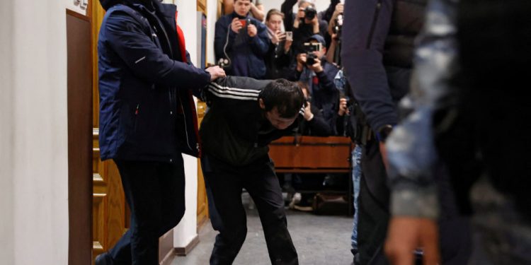 Shamsidin Fariduni, a suspect in the shooting attack at the Crocus City Hall concert venue, is escorted before a court hearing at the Basmanny district court in Moscow, Russia March 25, 2024. REUTERS/Yulia Morozova
