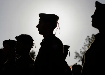 Israeli soldiers of the Netzah Yehuda Haredi infantry battalion stand at attention during their swearing-in ceremony [File: Ammar Awad/Reuters]