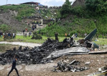 Officials examine the site after a Saurya Airlines' plane crashed during takeoff at the Tribhuvan International Airport in Kathmandu on July 24, 2024. A passenger plane crashed on takeoff in Kathmandu on July 24, with the pilot rescued from the flaming wreckage but all 18 others aboard killed, police in the Nepali capital told AFP. (Photo by PRAKASH MATHEMA / AFP)